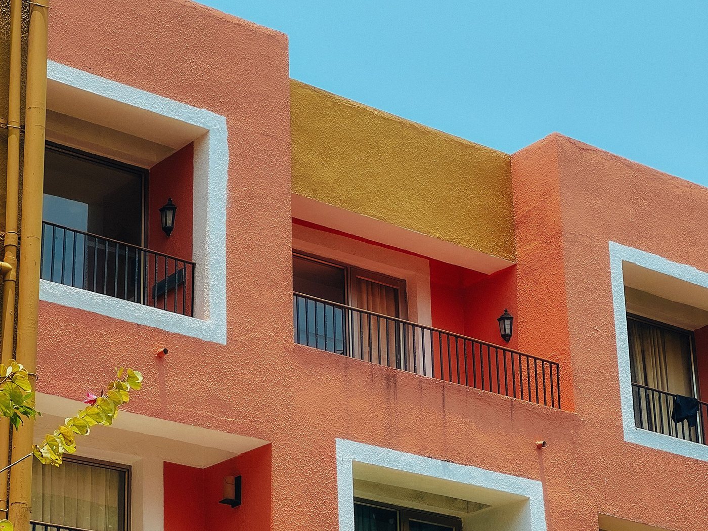 Façanes d'edificis de pisos de colors càlids amb balcons sota el cel blau