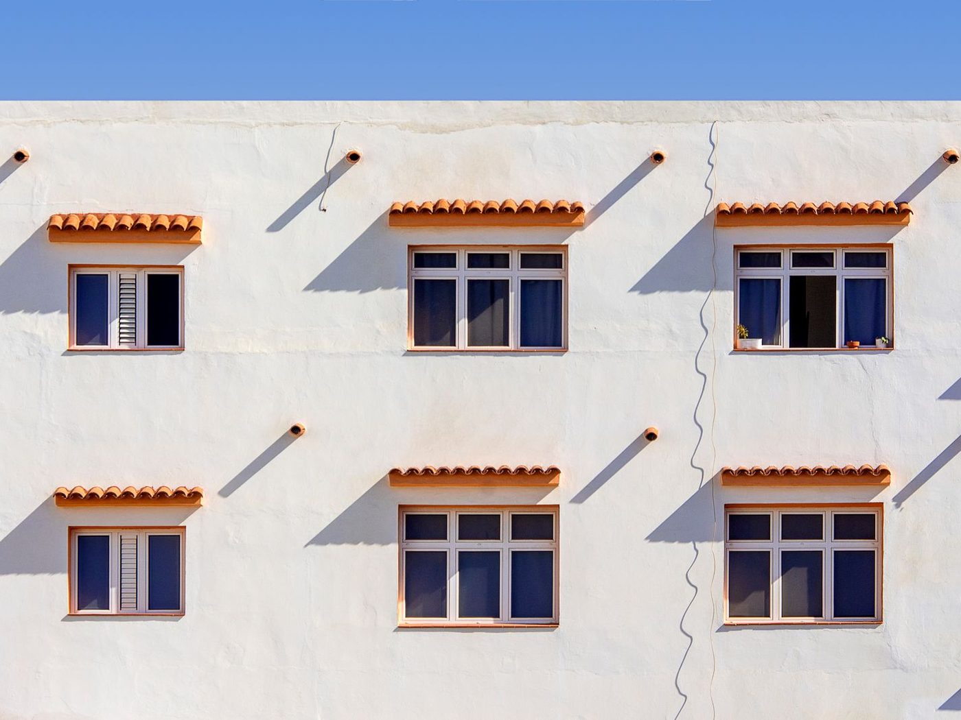 Façana d'habitatges amb finestres i teulada de teula