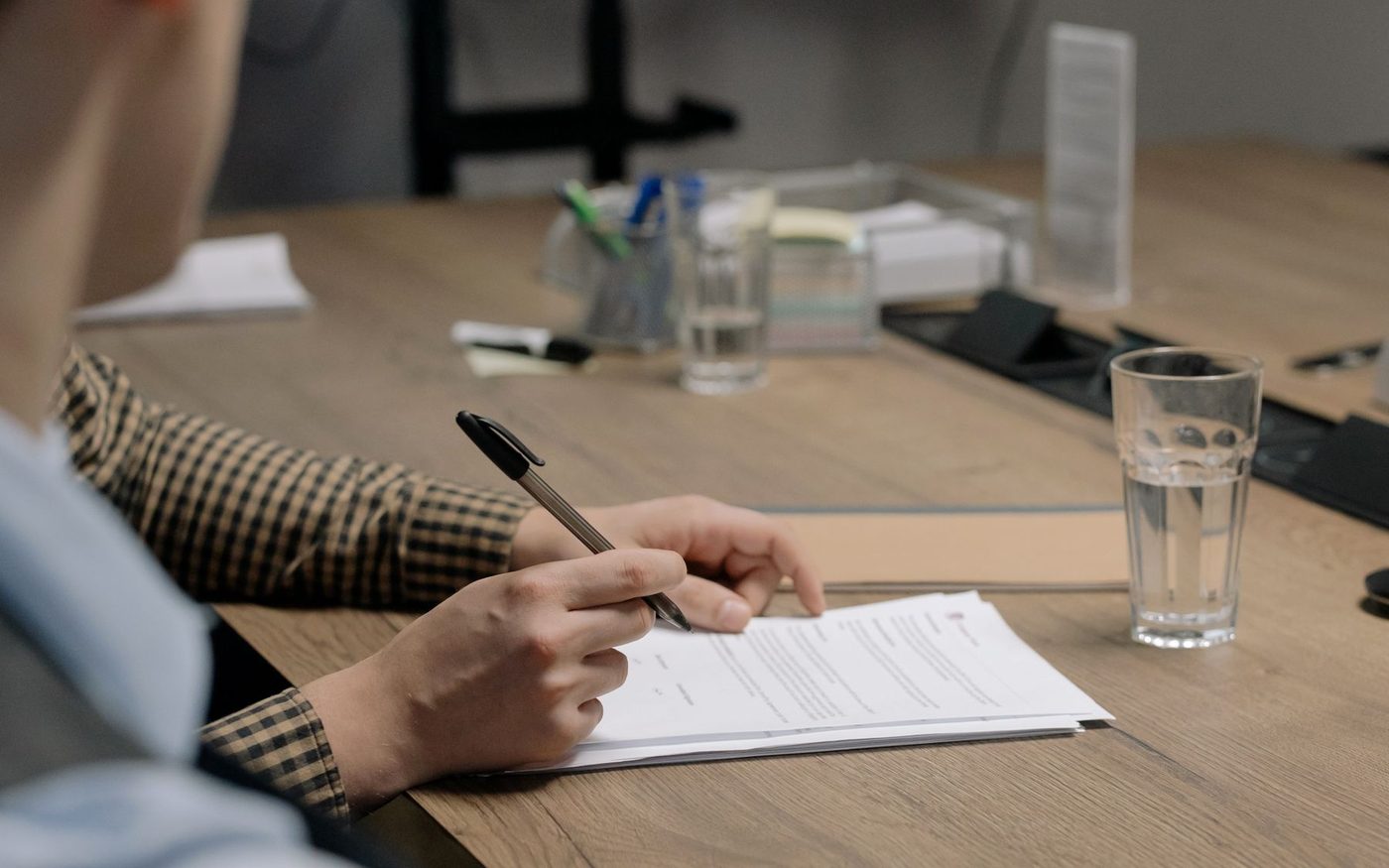 Persona signant documents en una taula