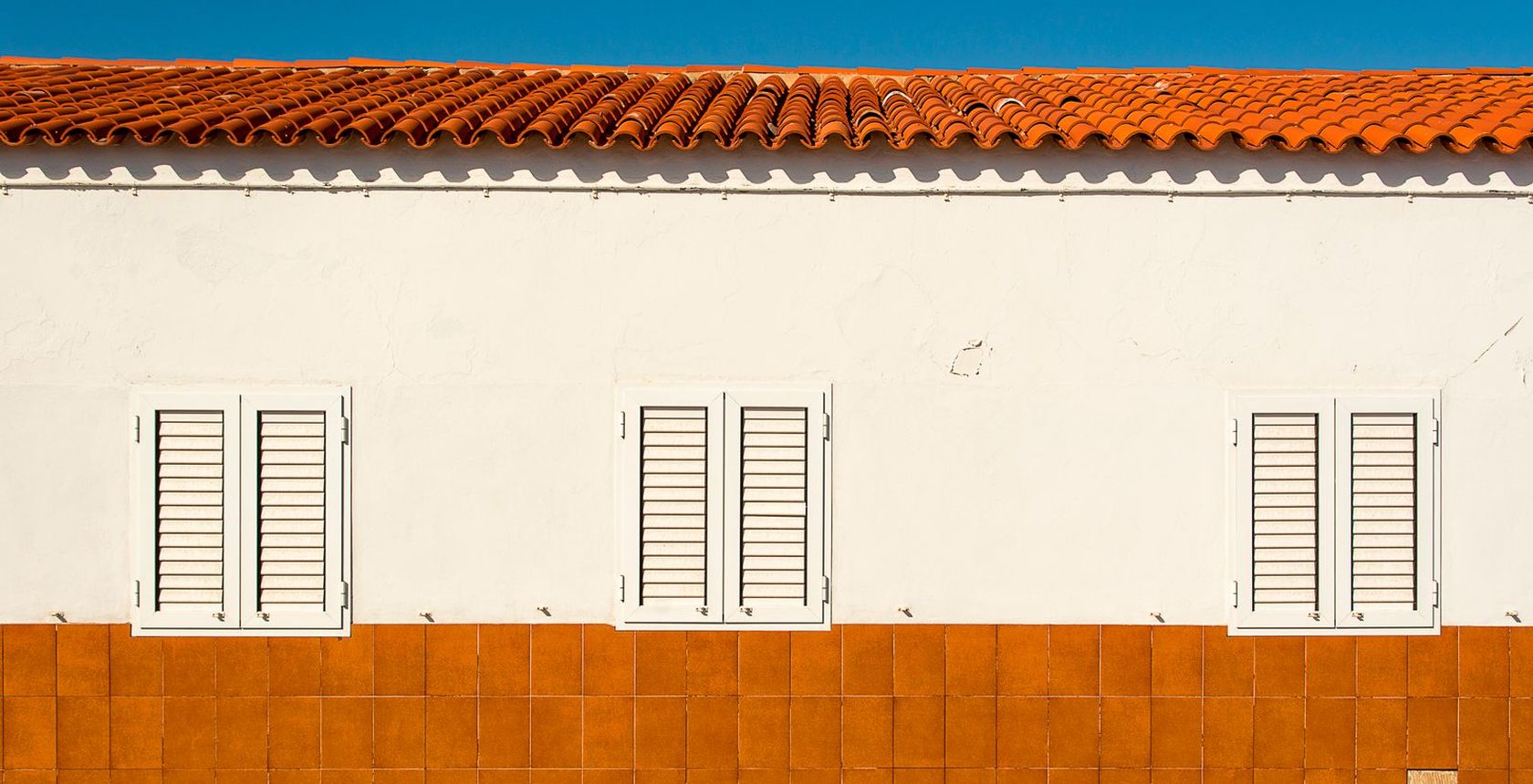 Façana blanca i terracota amb cel blau