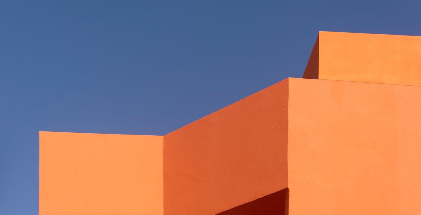 Façana de volums terracota sota un cel blau